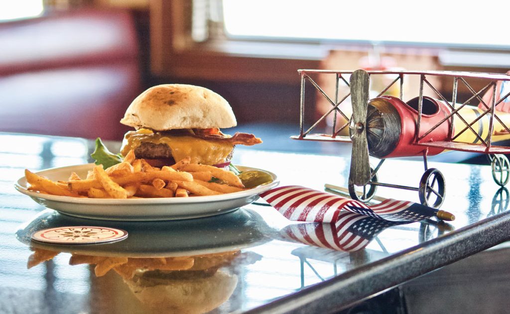 burger on table with toy plane