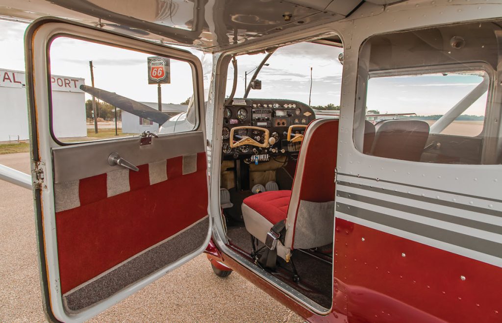 white and red cessna skylark with open door
